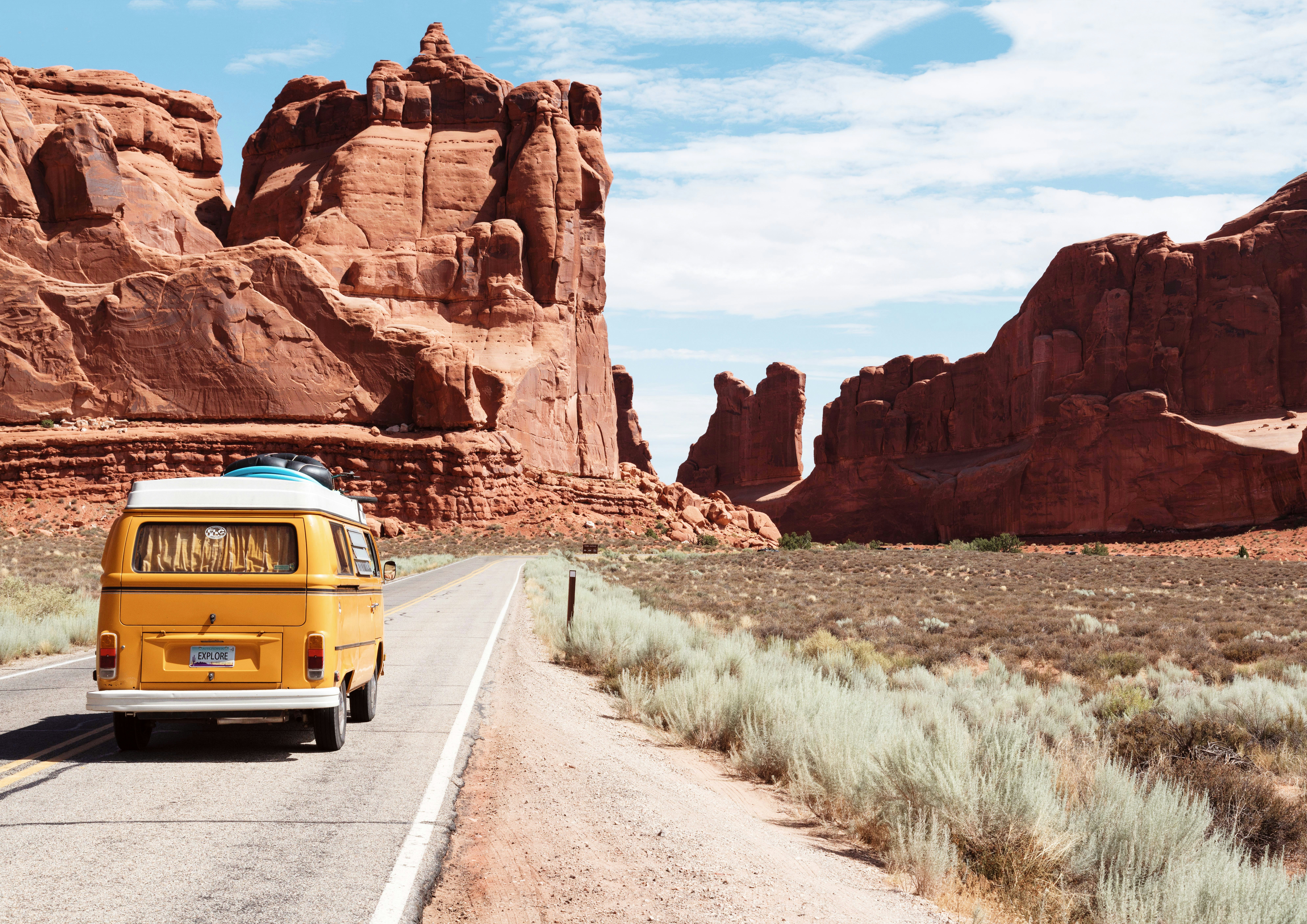 A westfalia driving through a beautiful desert landscape.